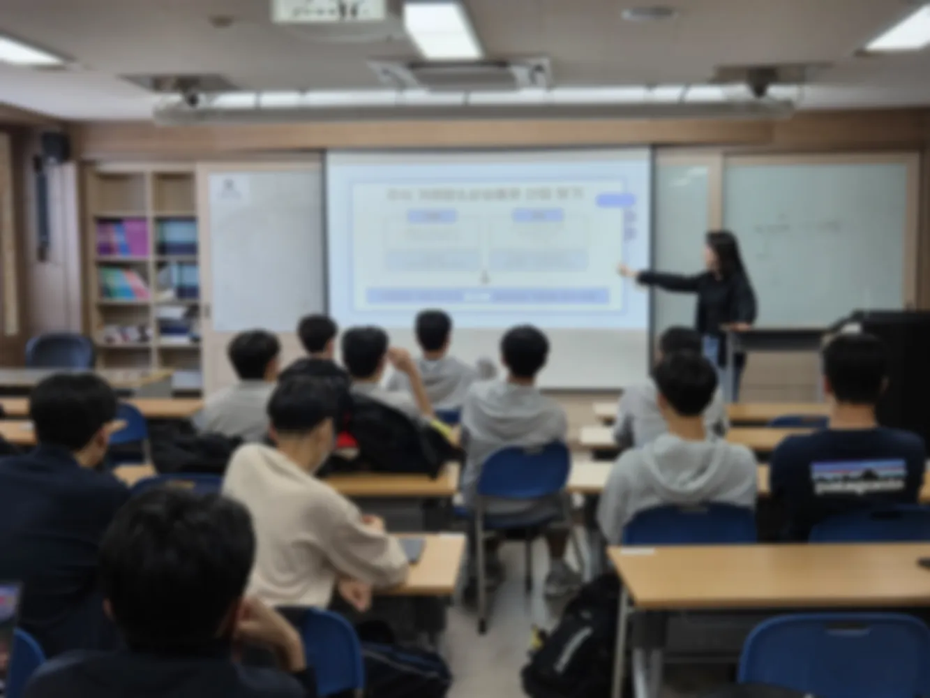 강사가 교실 앞에서 산업 분석 수업을 진행하는 모습